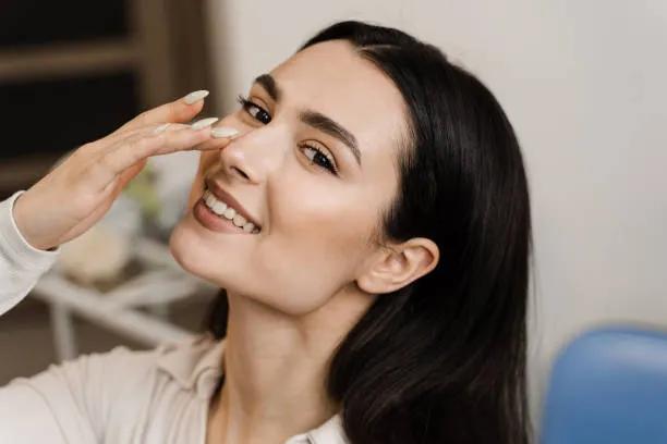 How does Rhinoplasty address nasal asymmetry?